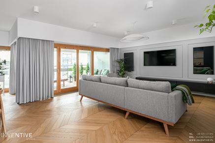 Nowoczesny salon w neutralnych tonach z szarymi: zasłonami, ścianami i kanapą