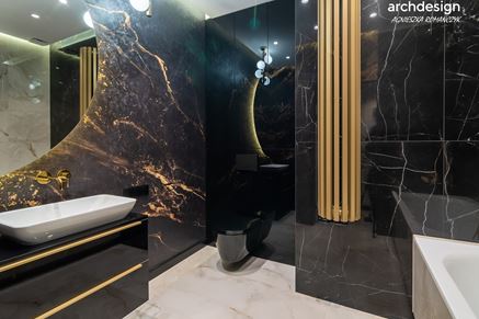 Czarna łazienka ze złotym grzejnikiem dekoracyjnym