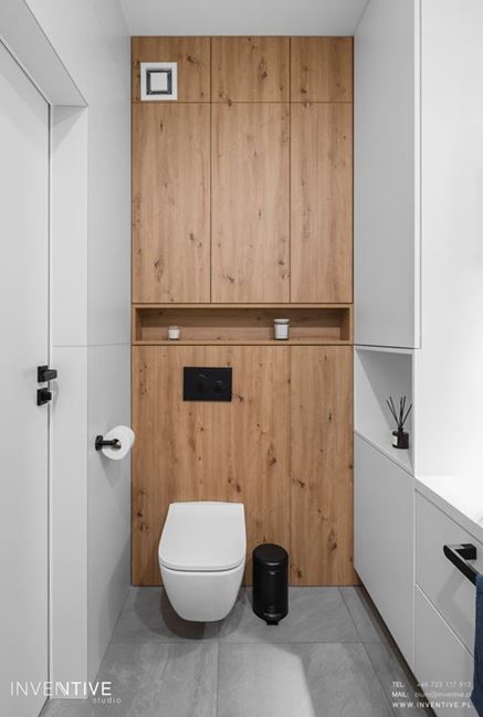 Toaleta wisząca na drewnianej zabudowie w łazience