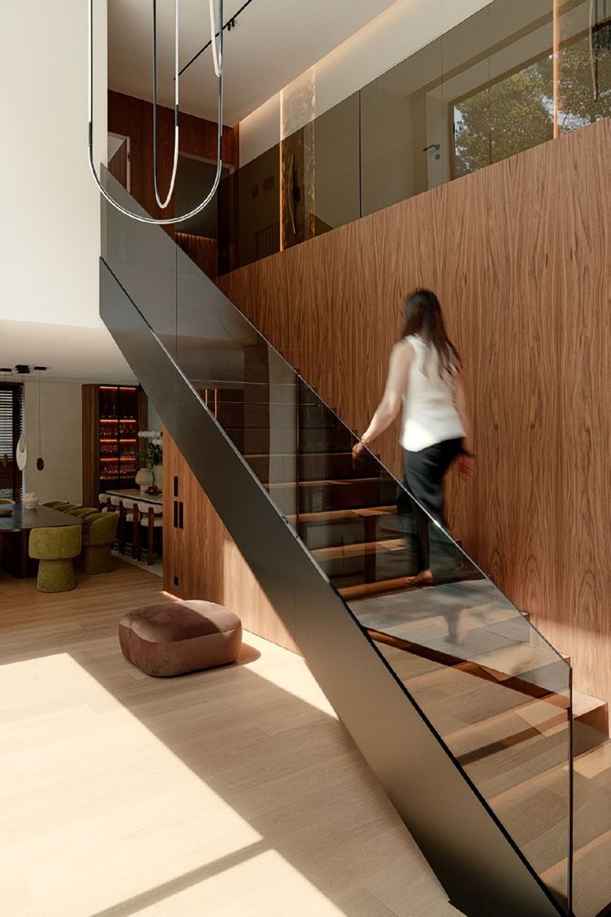 Klatka schodowa z drewnem orzechowym i szklaną balustradą, projekt SAAN Architects.jpg