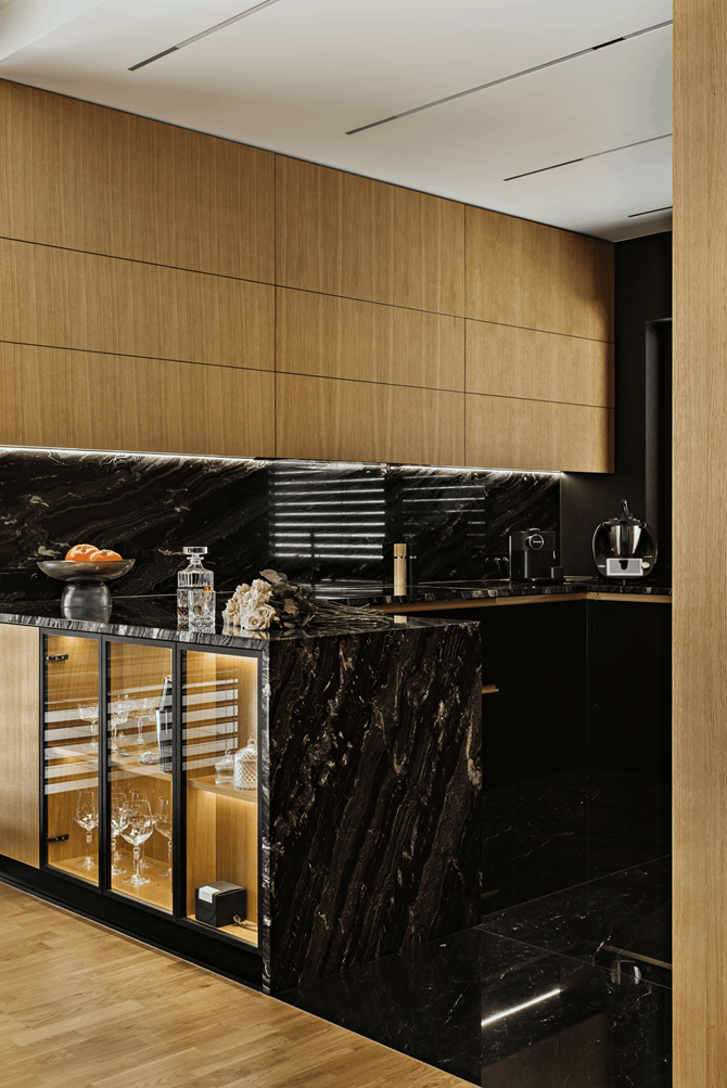 Kuchnia z drewnerm i czarnym kamieniem, projekt AVO Architects