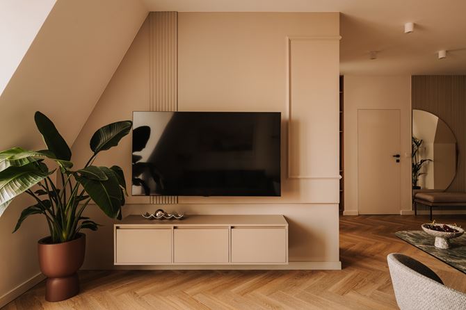 Ściana telewizyjna z asymetrycznymi sztukateriami, projekt MOIE studio