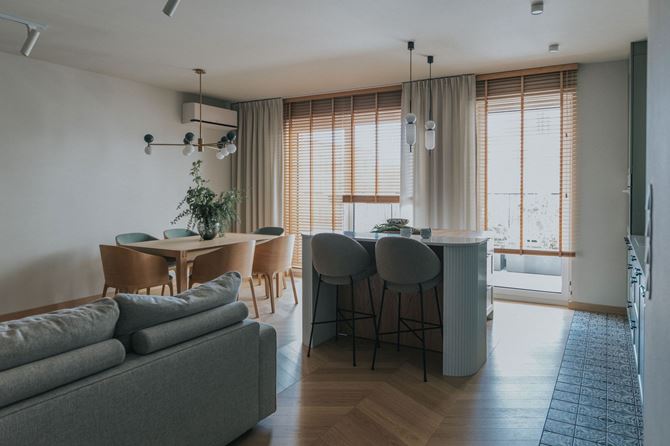 Kuchnia z wyspą i strefa jadalni w salonie w realizacji projektu TYMA PROJEKT