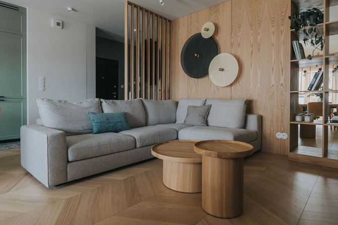 Salon z fornirowaną ścianą i okrągłymi kinkietami, projekt TYMA PROJEKT