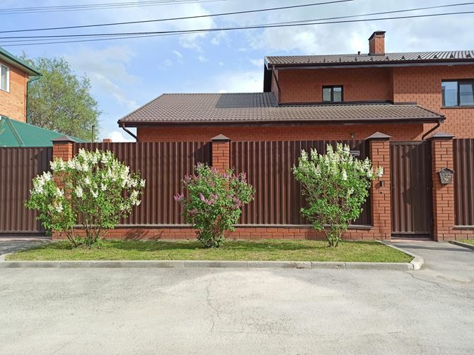 Ogrodzenie klinkierowe z metalowymi, brązowymi panelami