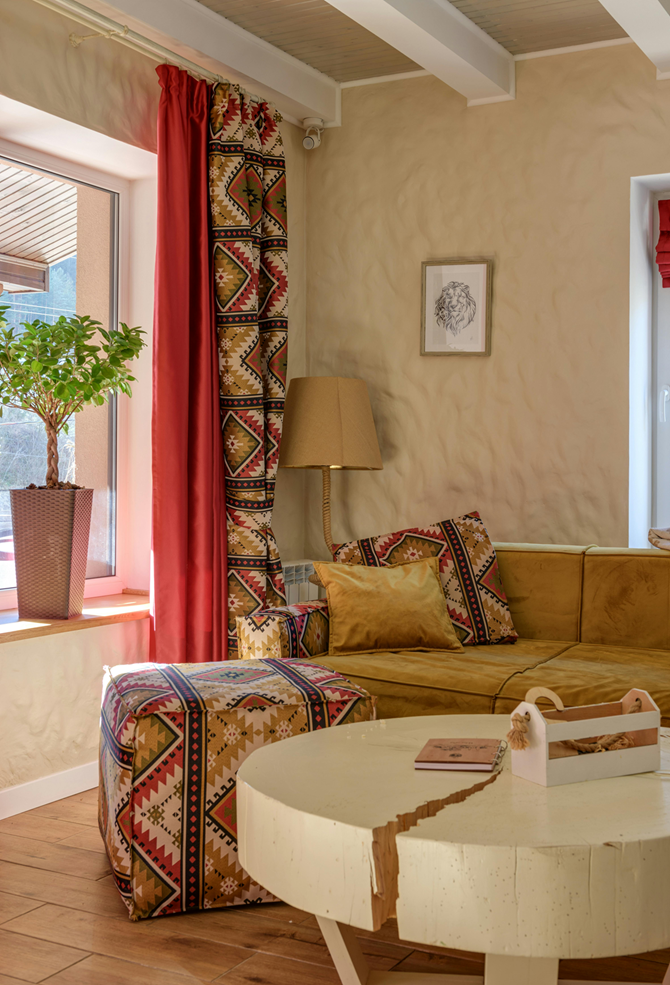 Salon w stylu boho utrzymany w ciepłych kolorach, z wzorzystymi tkaninami.png