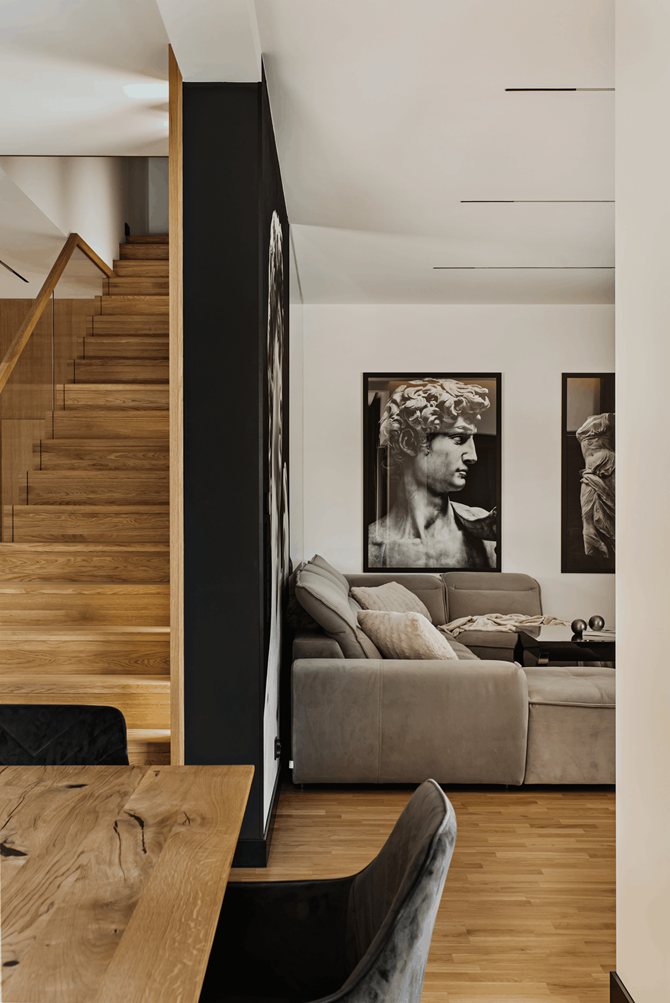 Salon wypoczynkowy z dużymi, czarno-białymi plakatami na ścianach, projekt AVO Architects