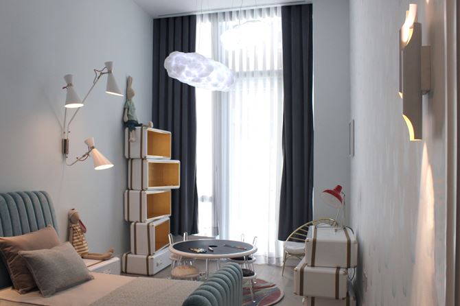 Jasny pokój chłopca z łóżkiem, stolikiem, krzesełkami i asymetrycznym regałem