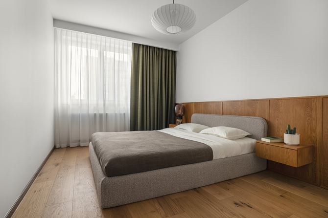 Biała aranżacja sypialni z drewnianym panelem, projekt Decoroom