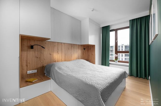 Sypialnia z biało-drewnianymi zabudowami przy łóżku