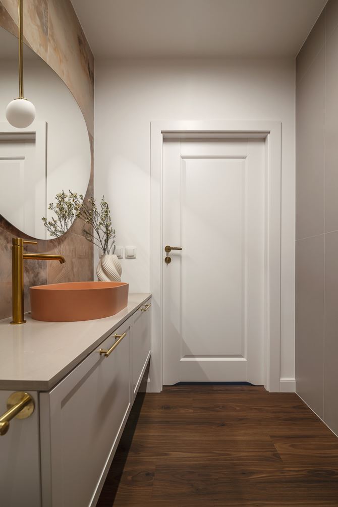 Jasna łazienka z koralową umywalką i płytkami podobnym kolorze, projekt Decoroom