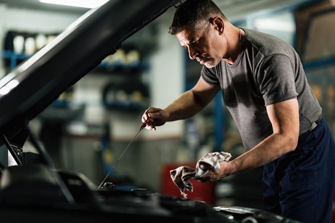 mid-adult-mechanic-examining-car-oil-auto-repair-shop (2)-min.jpg
