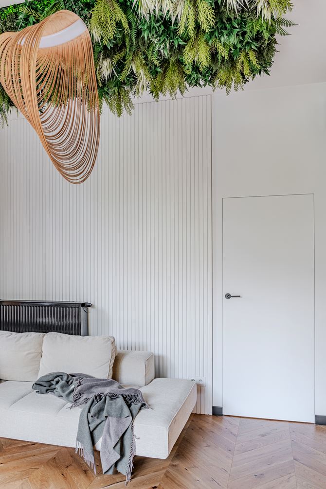 Detale salonu z białymi strukturami i zielenią na suficie w projekcie Deer Design
