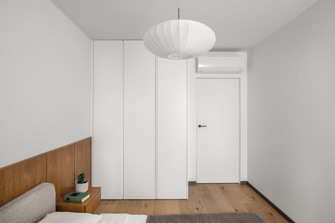 Białe szafy w jasnej sypialni, projekt Decoroom