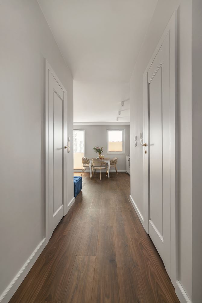 Biały korytarz z ciemną podłoga, projekt Decoroom