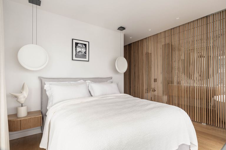 Biała sypialnia z ażurową ścianką z lamelami