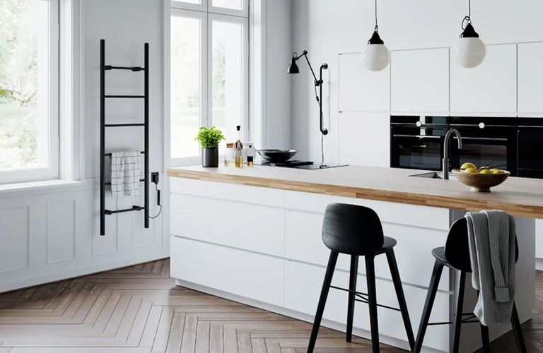 Jasna kuchnia z dużą wyspą i zabudowanym AGD