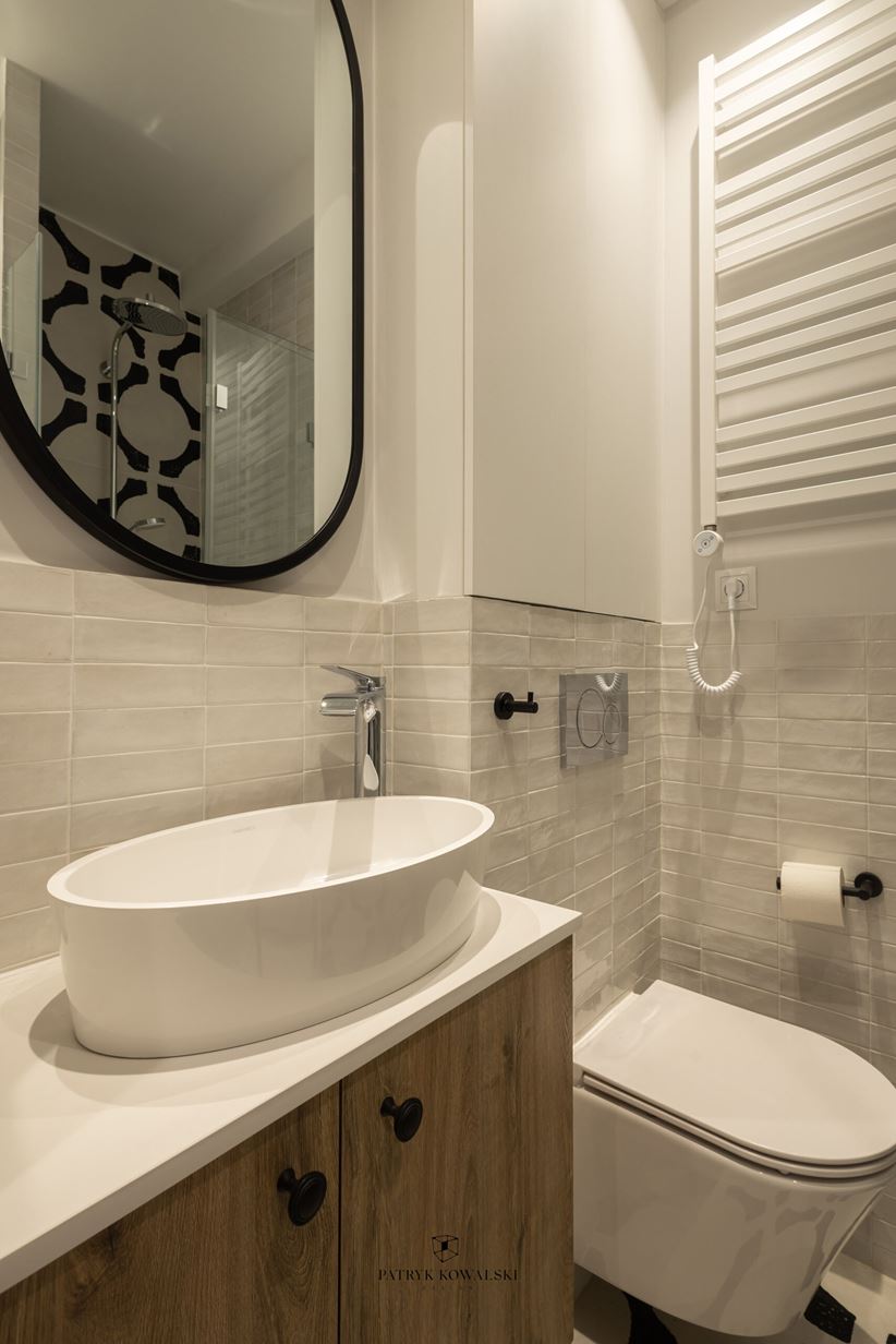 Łazienka z białą cegiełką i owalną umywalką blatową