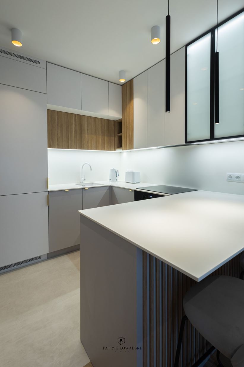 Aranżacja kuchni z asymetrycznymi szafkami wiszącymi