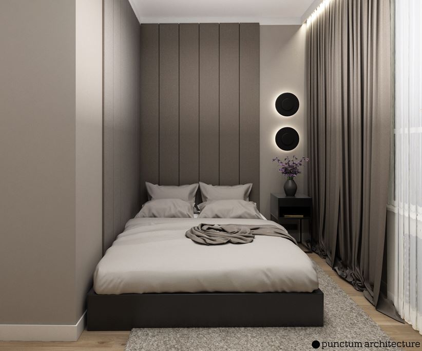 Wąska, szara sypialnia z wysokimi panelami tapicerowanymi