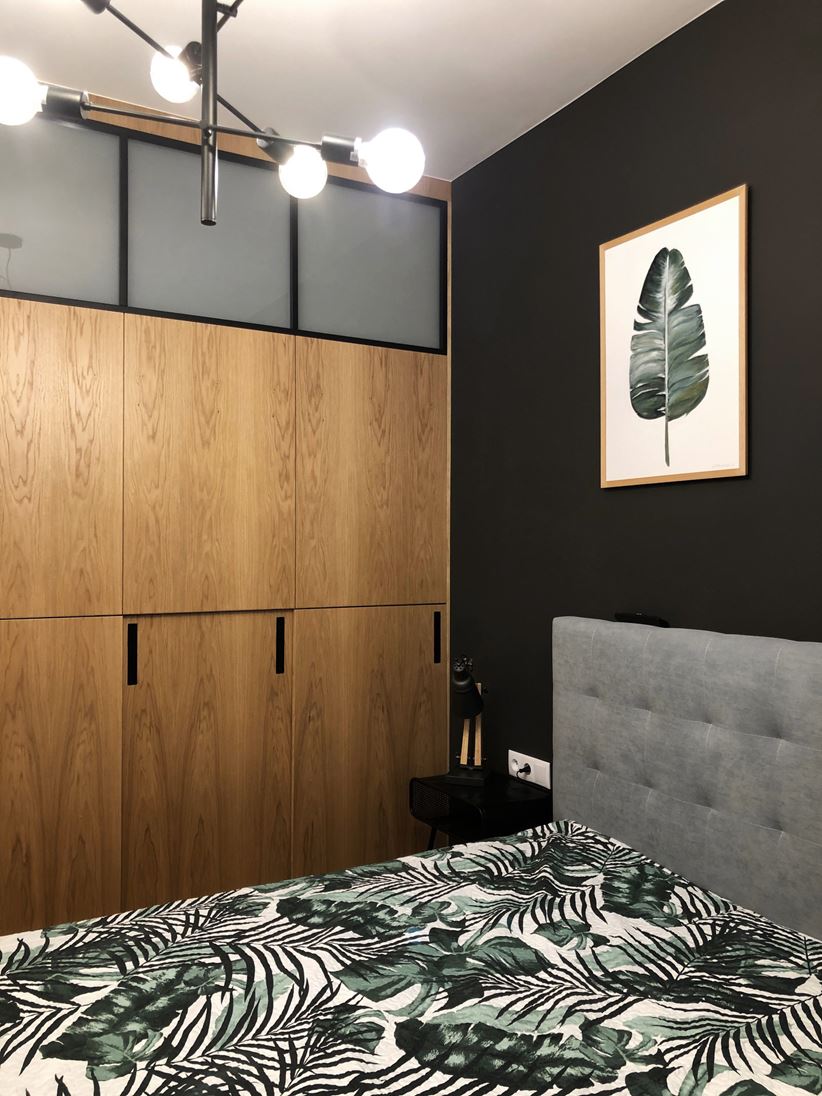 Mała sypialnia z drewnem i czernią