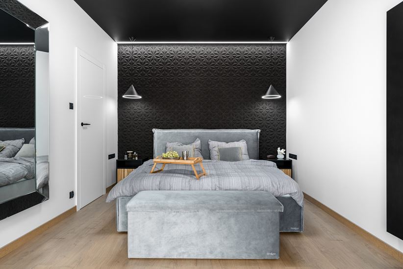 Biała sypialnia z czarną tapetą za łóżkiem i czarnym sufitem