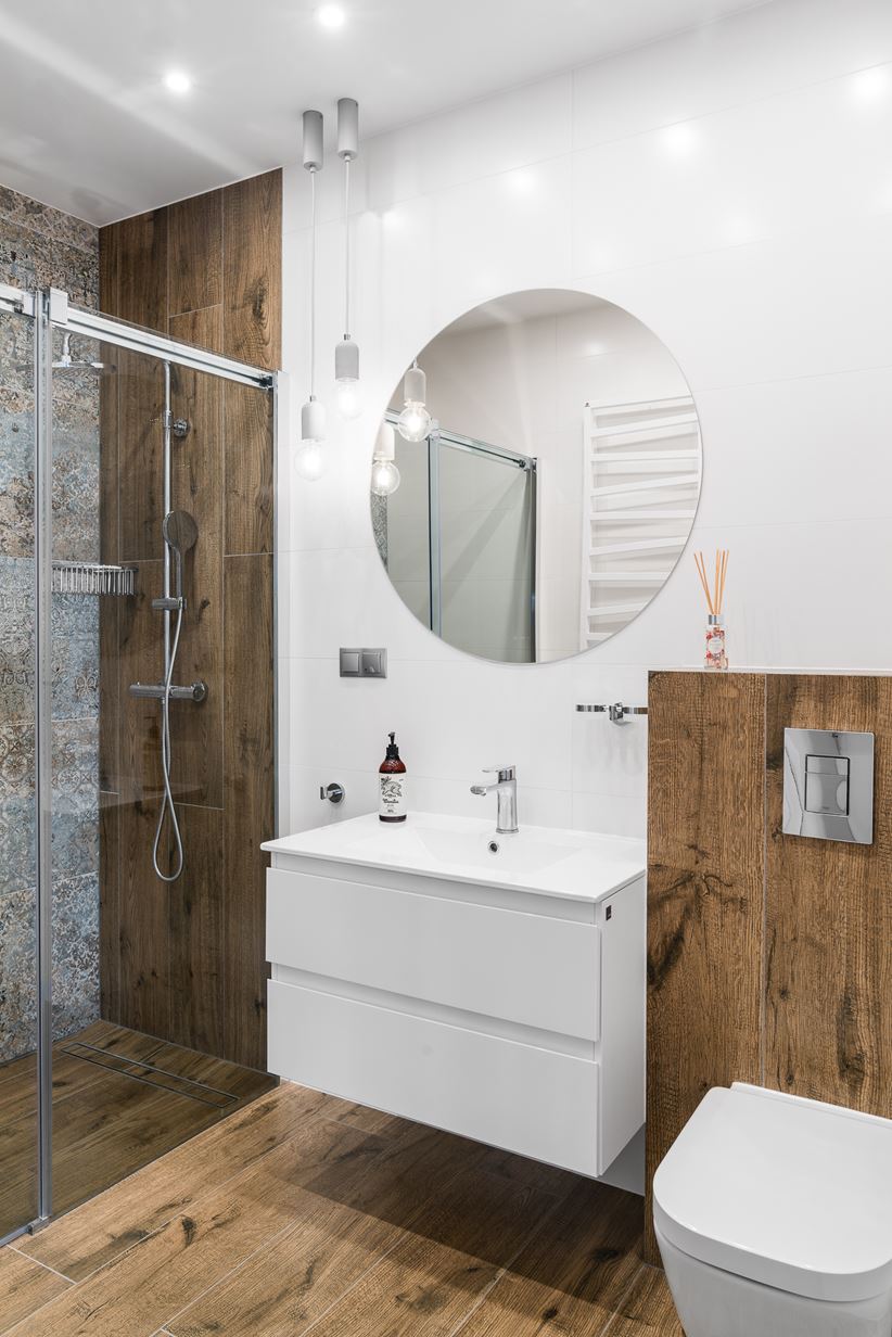 Biała łazienka z płytkami drewnopodobnymi i prysznicem