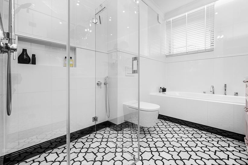 Podłoga w jasnej łazience wykończona geometryczną mozaiką z serii Dunin Manorial