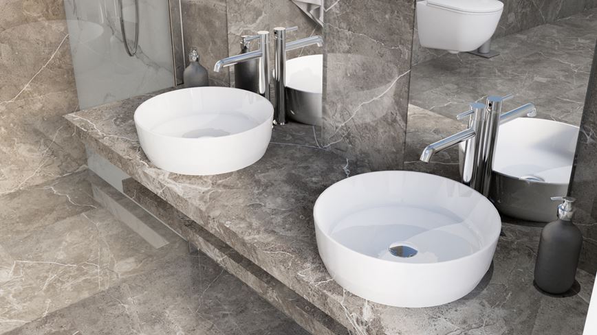 Umywalki stawiane na blat w otoczeniu szarych płyt z wzorem marmuru